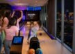 Friends bowling on private lanes inside the Kingpin Suite, one of the most famous Las Vegas themed rooms at Palms Casino Resort